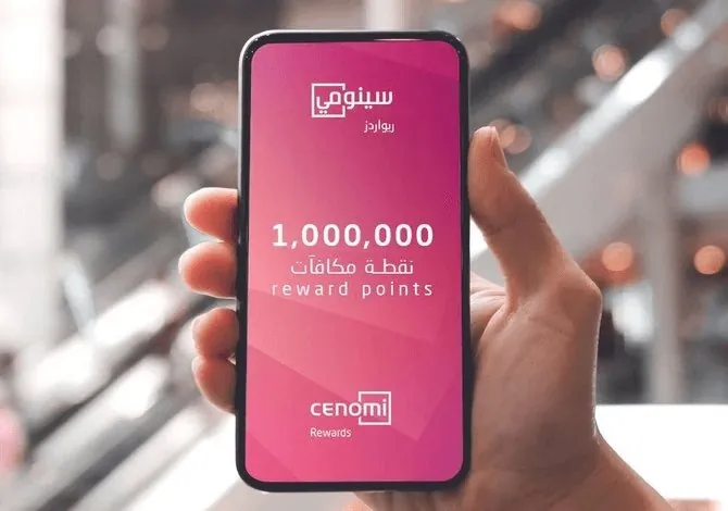 A hand holding a phone showing 1,000,000 reward points on the Cenomi Rewards splash in Arabic and English.